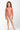 Young girl wearing a pink patterned swimsuit on a white background