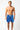 Man wearing blue swim shorts with a white pattern on a white background