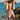 Man drying off with a towel on a beach with clear blue water and rocks.