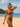 Woman in a rust-colored bikini standing on a beach with ocean and sky in the background