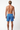 Man wearing blue patterned swim shorts on a white background