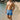 Man wearing blue patterned swim shorts standing on a beach