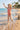 Child in a red swimsuit running on a beach with palm trees in the background