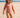 Child in a patterned swimsuit on a sandy beach with clear blue sky
