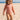 Child in a patterned swimsuit on a sandy beach with clear blue sky