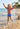 Child playing on a beach with palm trees in the background