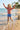 Child playing on a beach with palm trees in the background